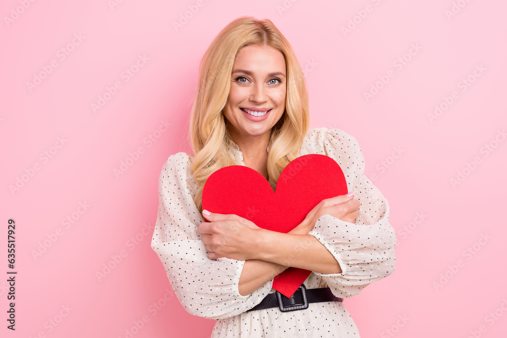 Photo portrait of lovely blonde woman hold hugging red heart shape dressed stylish white garment isolated on pink color background Photo portrait of lovely blonde woman hold hugging red heart shape dressed stylish white garment isolated on pink color background
