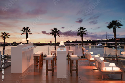 3D illustration of a modern rooftop bar overlooking a harbor at sunset