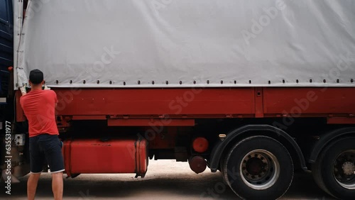 truck for transportation. Men unload a sheet of hardboard