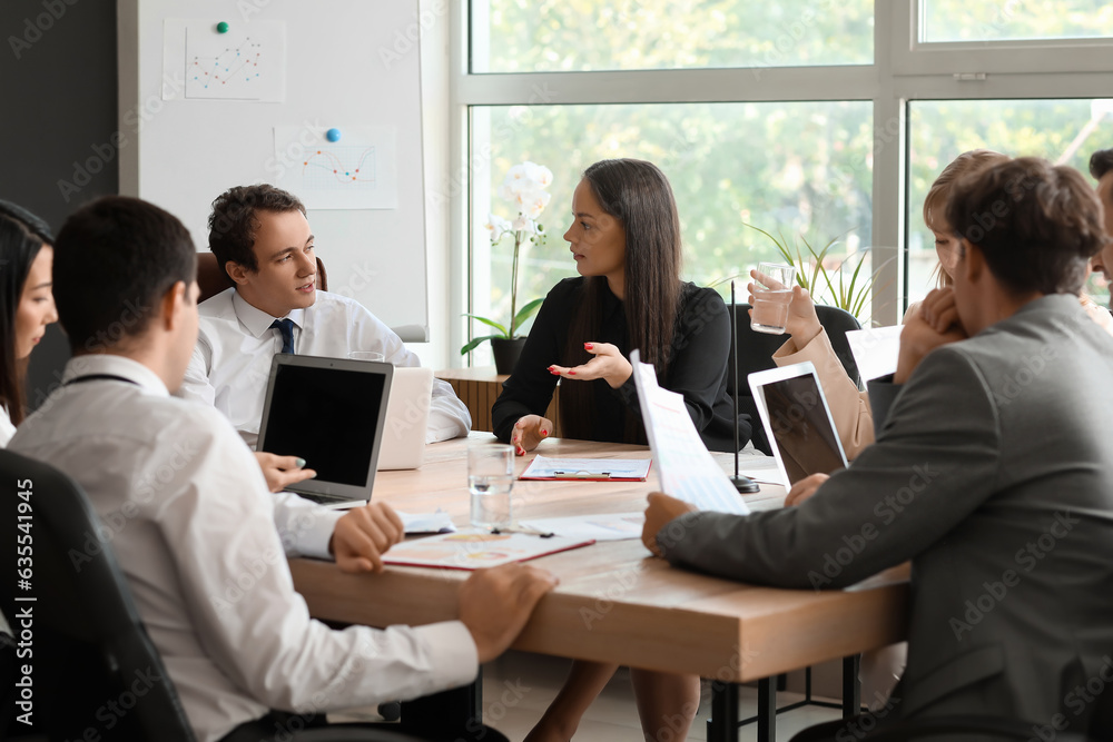Group of business consultants working at table in office Group of business consultants working at table in office