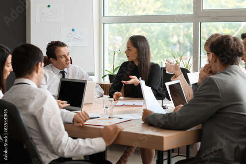 Group of business consultants working at table in office