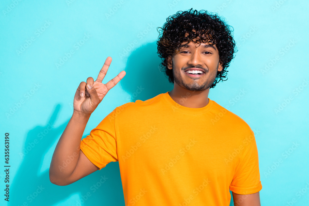 Photo of cheerful satisfied person beaming smile hand fingers demonstrate v-sign isolated on turquoise color background Photo of cheerful satisfied person beaming smile hand fingers demonstrate v-sign isolated on turquoise color background