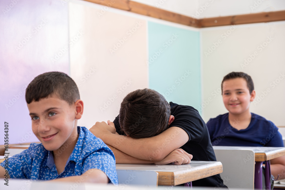 Student putting his head on the desk ,looks not feeling well or sleeping Student putting his head on the desk ,looks not feeling well or sleeping