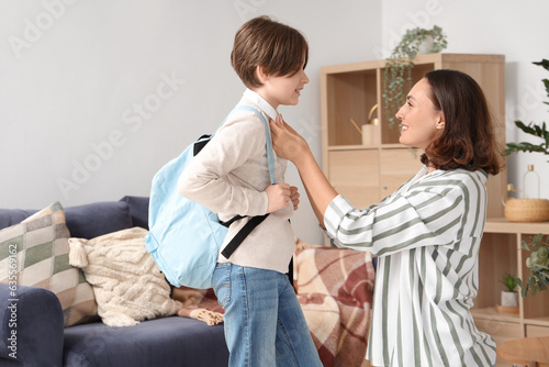 Mother getting her little son ready for school in living room
