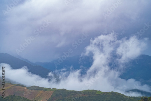 The stunning view from a tourist's standpoint as they go down a hill on a foggy trail in Nan, Thailand.