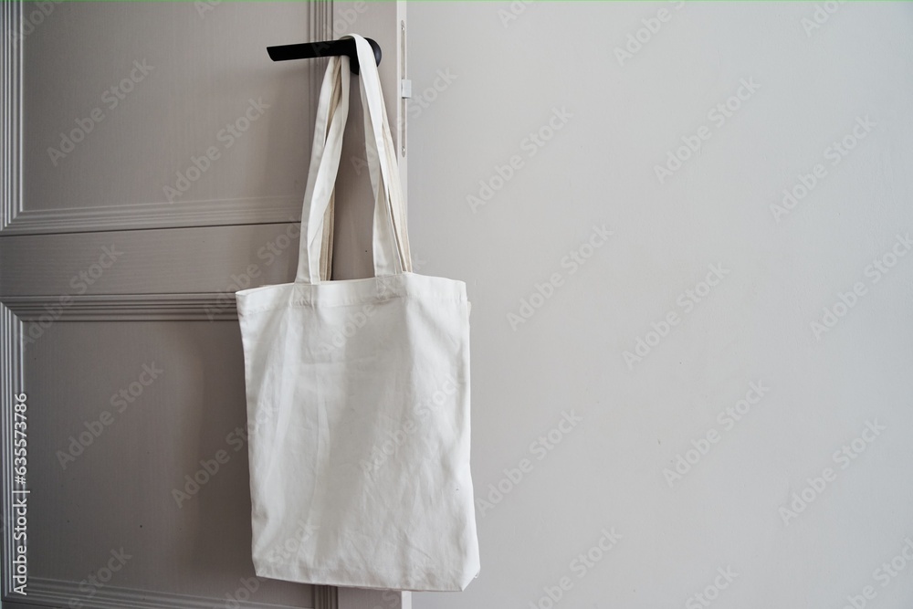Eco friendly concept with white canvas tote bag hanging on door knob