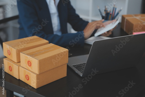 Starting small businesses SME owners female entrepreneurs Write the address on receipt box and check online orders to prepare to pack the boxes, sell to customers, sme business ideas online. © Sirikarn Rinruesee