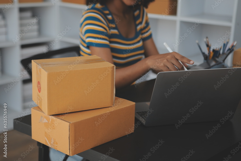Fototapeta premium Starting small businesses SME owners female entrepreneurs Write the address on receipt box and check online orders to prepare to pack the boxes, sell to customers, sme business ideas online.