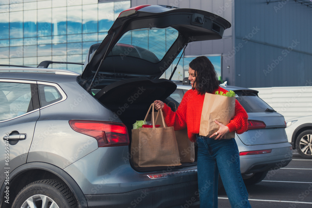 smiling woman put bags in car trunk