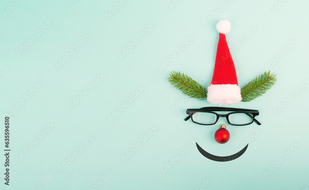 Face of a reindeer with a red bauble nose, fir antlers, a santa claus hat and eyeglasses, merry christmas greeting card Face of a reindeer with a red bauble nose, fir antlers, a santa claus hat and eyeglasses, merry christmas greeting card
