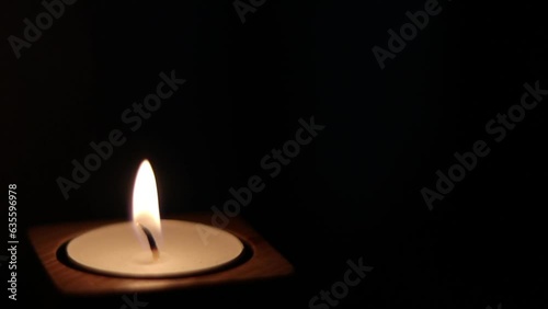 Close-up of flame burning on the candle isolated on a black background. Lighting wick with lighter