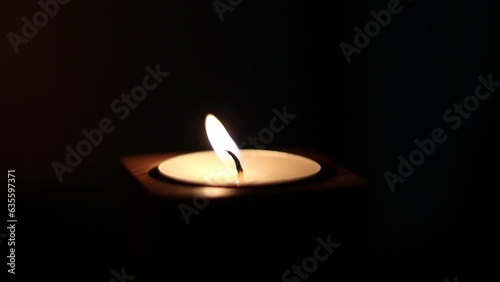 Close-up of flame burning on the candle isolated on a black background. Lighting wick with lighter