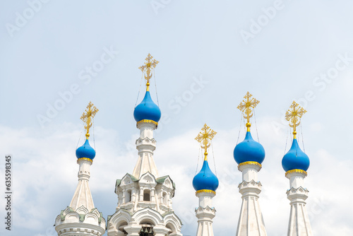 Close-up view of blue cupolas with golden crosses of Russian Orthodox Nativity Church at Putinki in Moscow against cloudy sky in a summer day. Copy space for your text. Religious architecture theme.