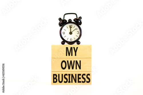 My own business symbol. Concept words My own business on wooden block. Beautiful white table white background. Black alarm clock. Business motivational my own business concept. Copy space.