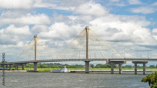 towboat with barges os passing under the Clark Bridge, a cable-stayed bridge across the Mississippi River between West Alton, Missouri and Alton, Illinois. photo