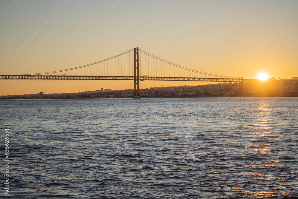 Sunset view over lisbon and 25 de Abril Bridge famous tourist landmark connecting Lisbon and Almada over Tagus river