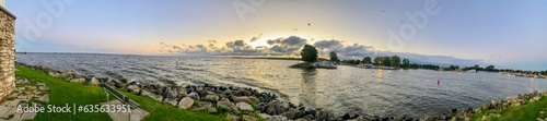 sunset  sun  water  sky  river  sunrise  lake  nature  landscape  sea  clouds  reflection  orange  evening  dusk  ocean  cloud  red  boat  horizon  light  travel  yellow  silhouette  summer sky  grass