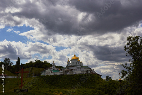 Orthodox church against backdrop of clouds in sky.