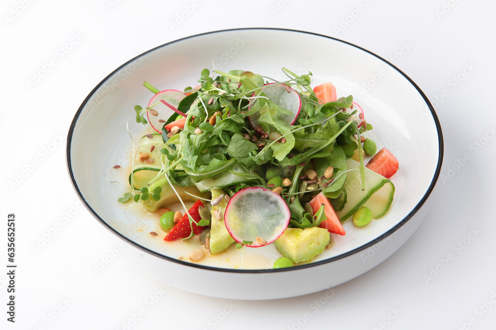 Vitamin salad. Salad of avocado, strawberries, cucumbers and lettuce leaves. Useful products. Healthy food.Copy space. Isolated object. Vitamin salad. Salad of avocado, strawberries, cucumbers and lettuce leaves. Useful products. Healthy food.Copy space. Isolated object.