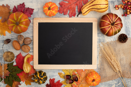 Festive autumn decor from pumpkins, leaves and ears of wheat. Concept of Thanksgiving or Halloween. Flat lay autumn composition with frame for text.