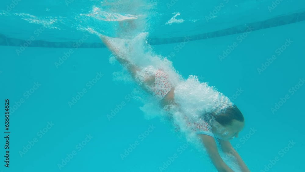 10 year old girl dives into pool, touches the bottom, resurfaces in slow motion