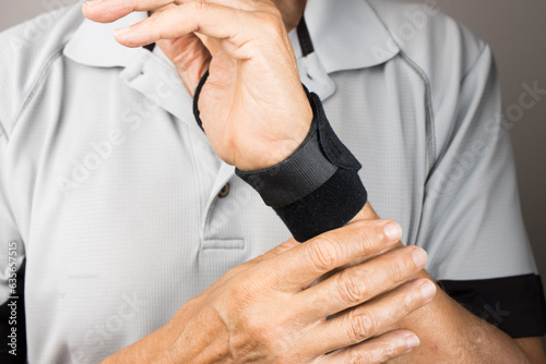 Man wearing a wrist brace or wrap on his left hand and wrist for pain management