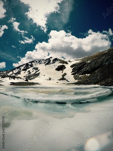 landscape of snowy mountains with a frozen lake in the sierra nevada in spain near mulhacen photo