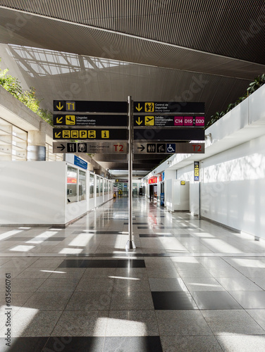 Aisle with signage in an airport. Commercial aisle of the international flights area of the Cali airport. In the middle of the corridor there is a sign with directions and signposting of the place