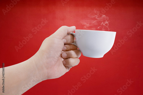 hand holding white coffee cup with red background