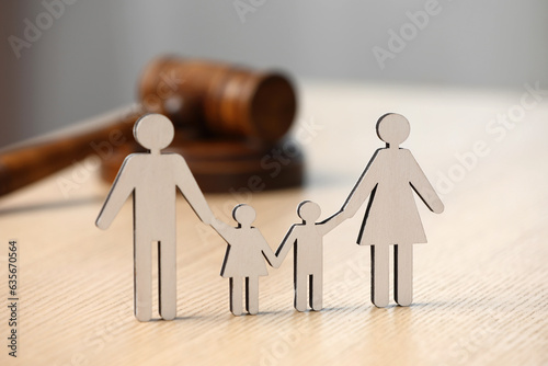 Family law. Figure of parents with children and gavel on wooden table photo