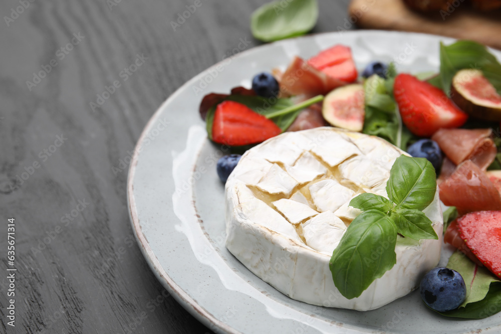 Delicious salad with brie cheese, blueberries, figs and strawberries on grey wooden table, closeup Delicious salad with brie cheese, blueberries, figs and strawberries on grey wooden table, closeup
