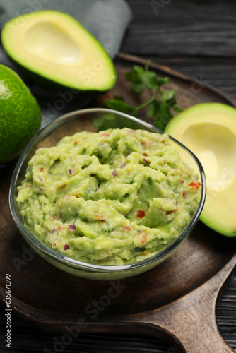 Delicious guacamole with parsley and fresh avocado on wooden board