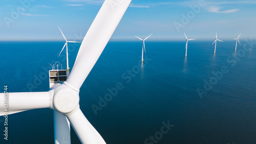Wind mill turbines with a blue sky, windmill park in the ocean aerial view with wind turbine Flevoland Netherlands Ijsselmeer. Green Energy production in the Netherlands