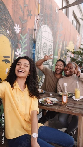 Three young multiracial friends in casual clothing taking selfie with mobile phone while enjoying lunch at vegan cafe