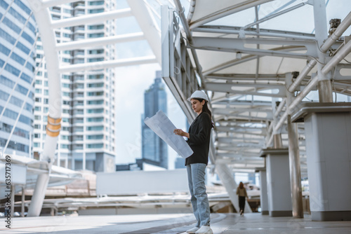 Wallpaper Mural Expert female architect reviews Skytrain site, cross referencing blueprint for project approval. Torontodigital.ca