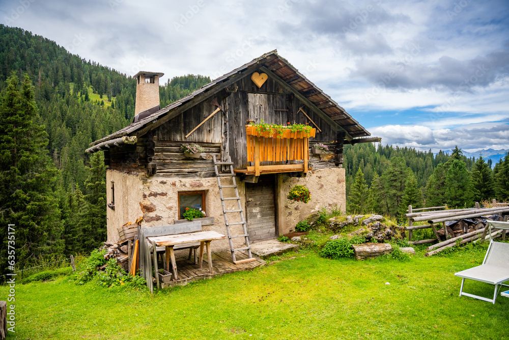 Obraz premium Dolomite landscape in Puez Odle Nature Park - view from alpine plateau with wooden houses and green meadows