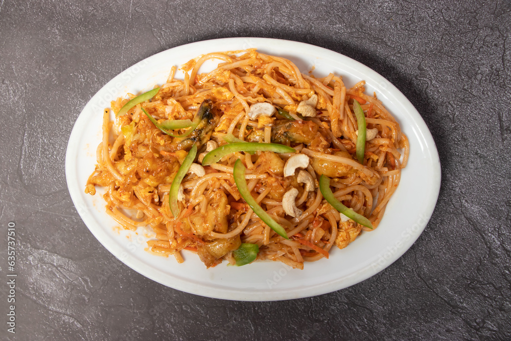 Special Chowmein with egg, chicken and cashew served in dish isolated on background top view of bangladesh food