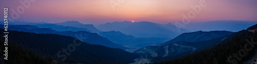 Panorama overlooking sunset of Dead Indian Pass near Cody, Wyoming during the Canada wildfires in spring of 2023

