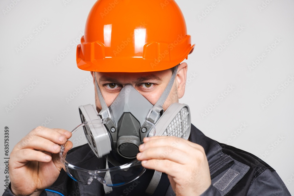 A man wearing a helmet, respirator and goggles on a white background A man wearing a helmet, respirator and goggles on a white background