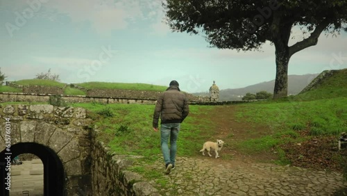 Man and a Dog walk through Ancient Castle Remains