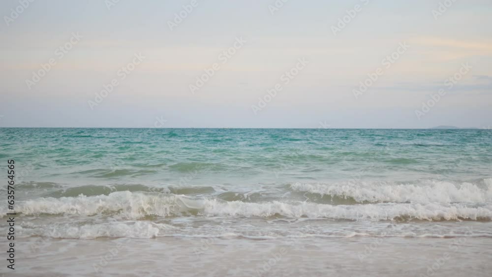 Foamy waves rolling towards the white sand beach. Ocean water waves splash the sandy beach. Foamy waves rolling towards the white sand beach. Ocean water waves splash the sandy beach.