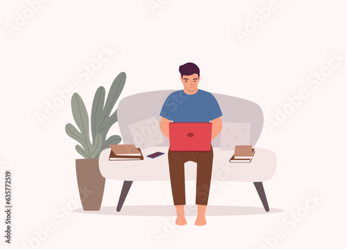One Smiling Man Sitting On Couch Working On Laptop At Home. Full Length.