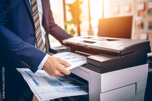 Businessman print paper on a multifunction laser printer in business office. Document and paperwork. Secretary work. Copy, print, scan, and fax machine. Print technology. Photocopy. photo