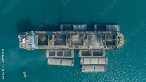 Powder Barge Ship load cement powder to large cargo ship in the Ocean export concept. powder material transportation by  ship. crane working load Cement Power.