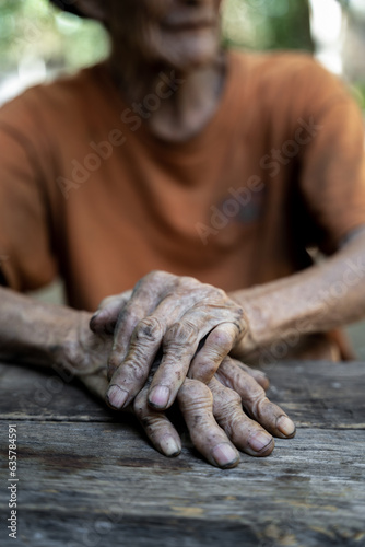 Elderly man holding hands on knees because of disease, health care or elderly concept.