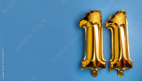 Banner with number 11 golden balloon with copy space. Eleven years anniversary celebration concept on a blue background.