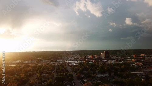 Aerial Ascending Forward Over Street Amidst Buildings Against Cloudy Sky At Sunset - Great Falls, Montana photo