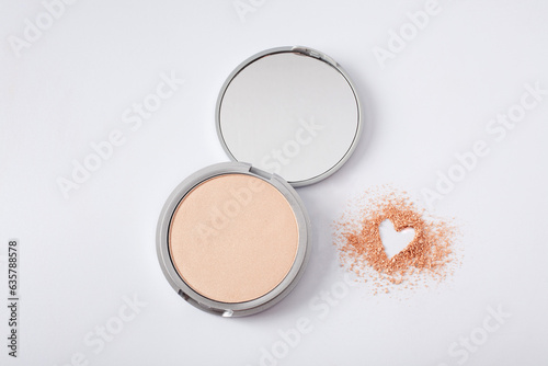 Beautiful eyeshadow palette on white with crushed sample heart shape. Makeup product