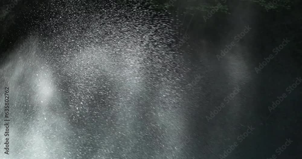 Close up, waterfall water splash on dark nature background. Water drops scatter from mountain waterfall splash in morning sunlight. Powerful water splash, closeup. Fresh splashing water. 4k abstract Close up, waterfall water splash on dark nature background. Water drops scatter from mountain waterfall splash in morning sunlight. Powerful water splash, closeup. Fresh splashing water. 4k abstract