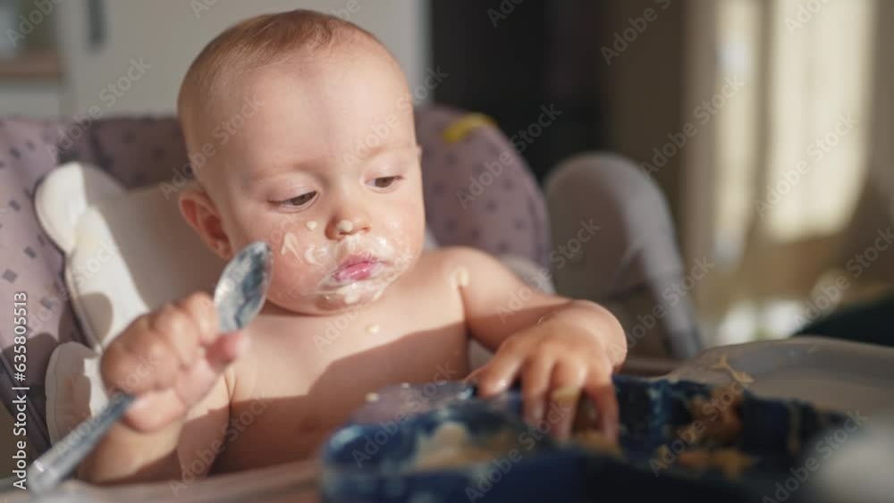 baby dirty eats. happy family a child toddler concept. baby dirty sitting lifestyle messing with food at the table for feeding in the kitchen. grimy toddler in the kitchen baby dirty eats. happy family a child toddler concept. baby dirty sitting lifestyle messing with food at the table for feeding in the kitchen. grimy toddler in the kitchen